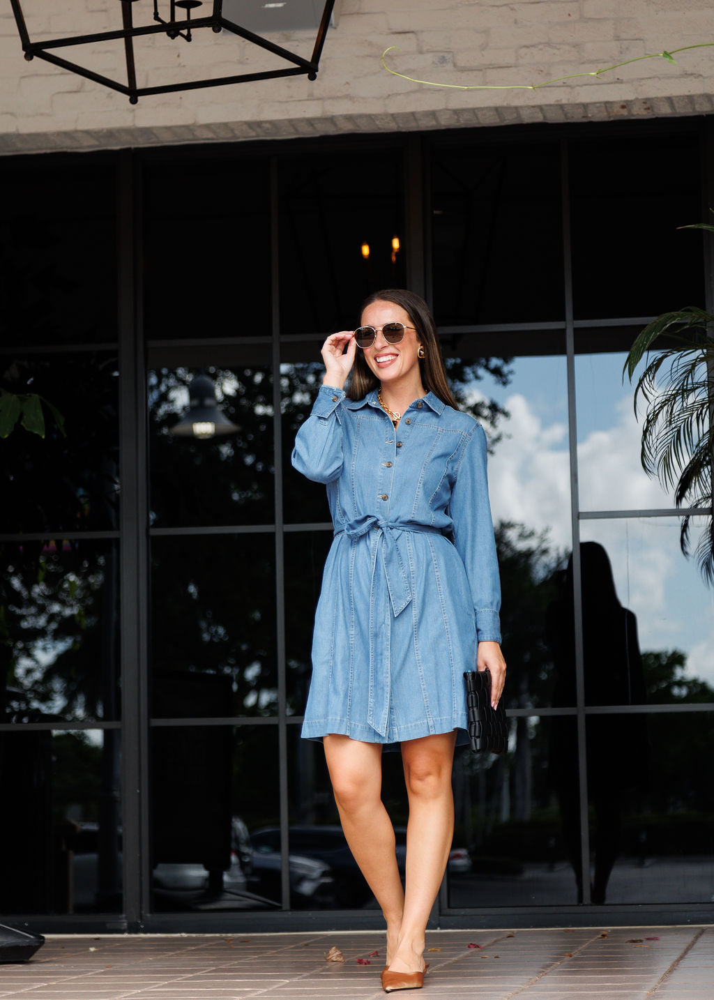 Hinson Wu Sabrina Long Sleeve Denim Dress in inMedium Wash paired with Le Specs Neptune Deux Sunglasses and Remi/Reid Lindy Large Woven Clutch Bag in Black available at Barbara Katz 